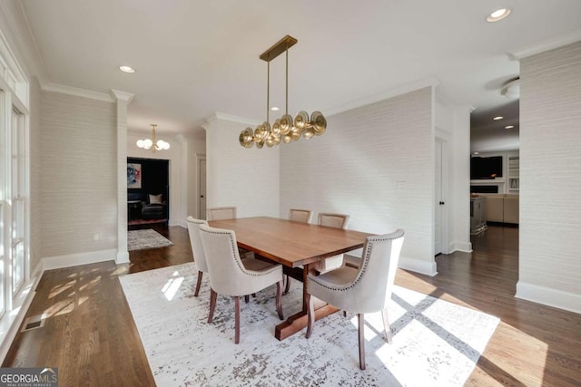 dining space featuring ornamental molding, wood finished floors, recessed lighting, baseboards, and a chandelier