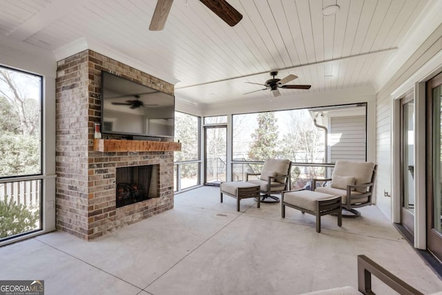 sunroom featuring a wealth of natural light, wooden ceiling, and a fireplace