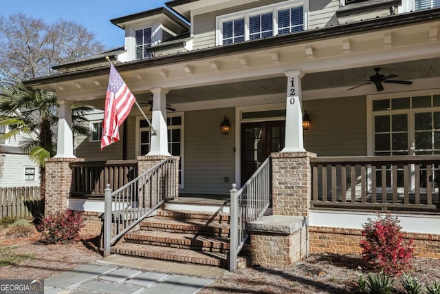 entrance to property featuring covered porch, a ceiling fan, and fence