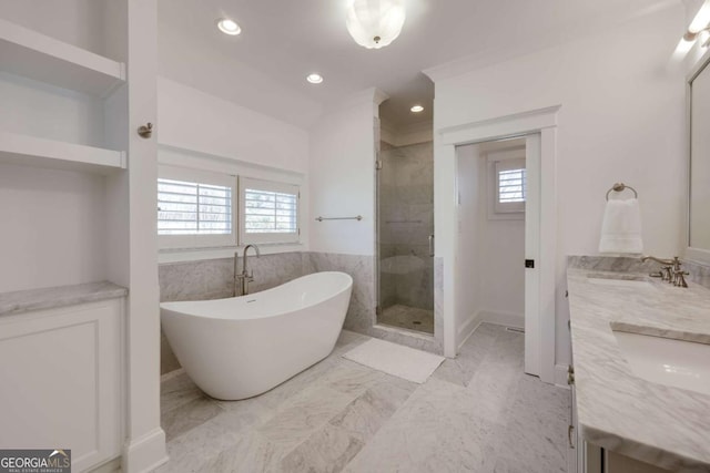 bathroom with a wealth of natural light, a freestanding bath, marble finish floor, and a shower stall