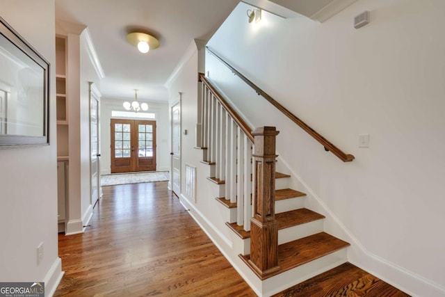 entryway featuring stairway, wood finished floors, baseboards, and french doors