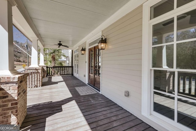 wooden deck featuring covered porch, french doors, and a ceiling fan