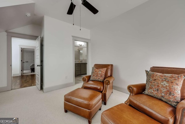 sitting room with vaulted ceiling, baseboards, carpet floors, and ceiling fan