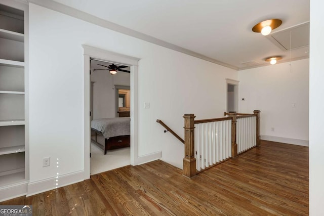 interior space featuring an upstairs landing, attic access, baseboards, and wood finished floors