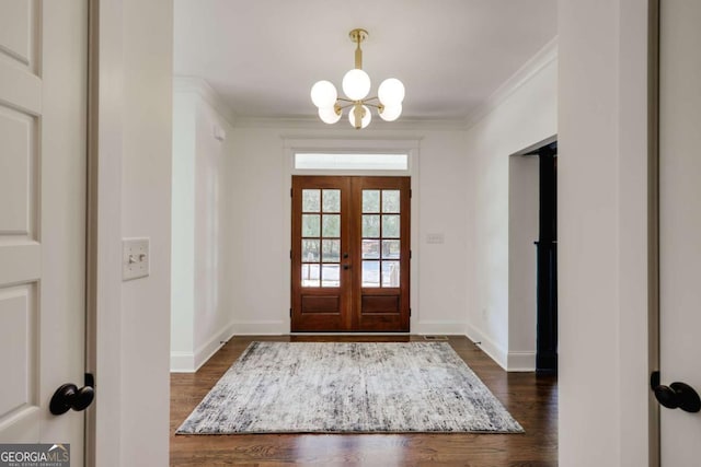 entryway featuring crown molding, baseboards, dark wood-type flooring, and a chandelier