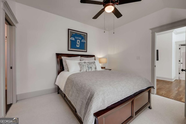 bedroom featuring light colored carpet, baseboards, and ceiling fan