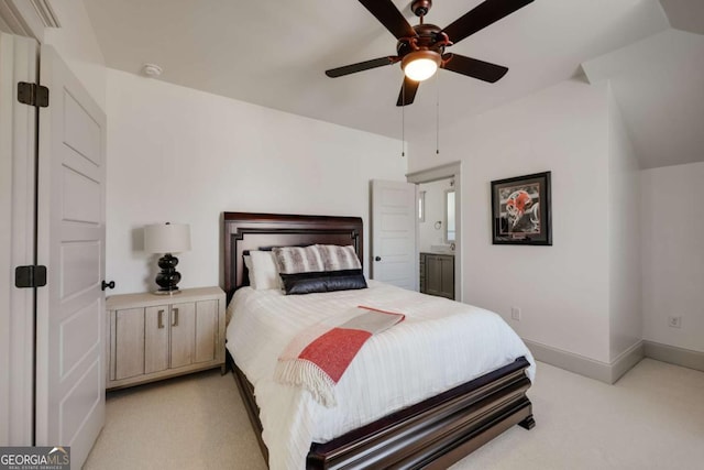 bedroom with lofted ceiling, ensuite bath, baseboards, light colored carpet, and ceiling fan