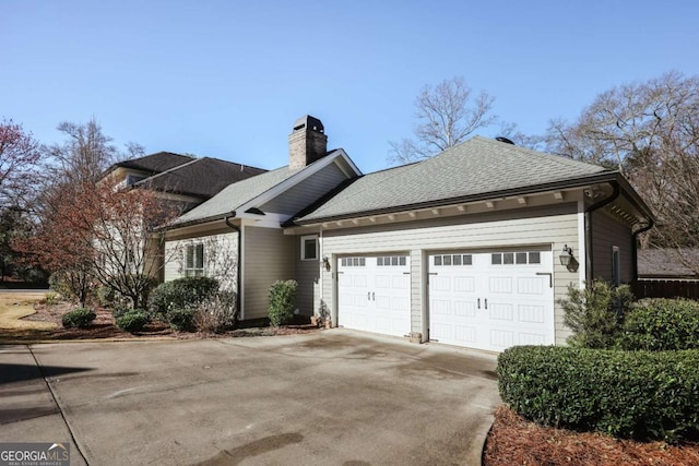 view of front of property featuring a chimney, driveway, a shingled roof, and a garage