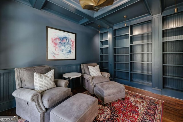 living area featuring built in features, a wainscoted wall, coffered ceiling, and wood finished floors