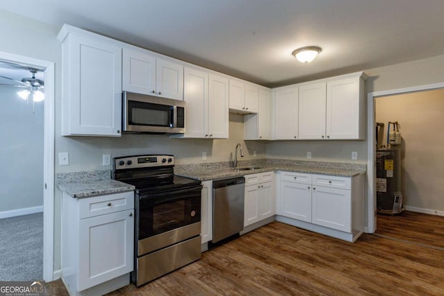 kitchen with a sink, white cabinets, water heater, and stainless steel appliances