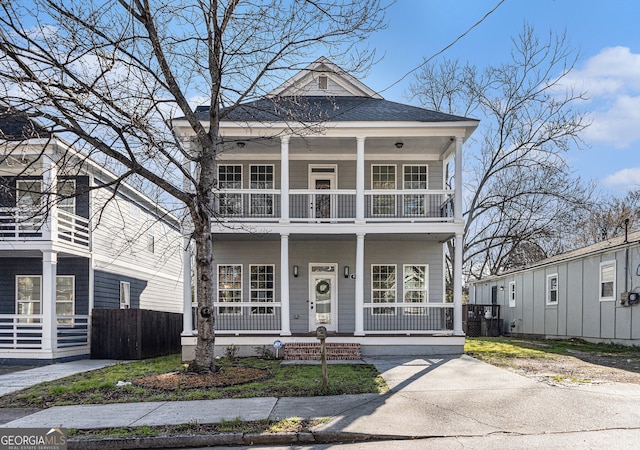 view of front of house featuring covered porch, a balcony, and roof with shingles