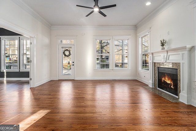 unfurnished living room featuring ornamental molding, a fireplace, a ceiling fan, and wood finished floors
