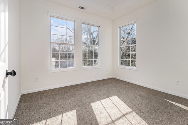 carpeted spare room with visible vents, baseboards, and ornamental molding