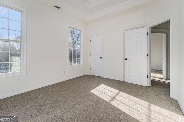 unfurnished bedroom with carpet flooring, baseboards, crown molding, and visible vents