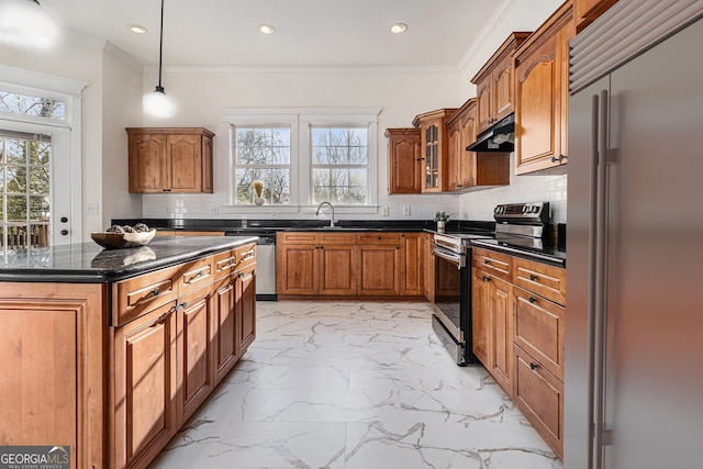 kitchen with stainless steel appliances, marble finish floor, under cabinet range hood, brown cabinets, and backsplash