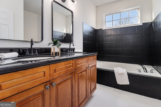 bathroom with a garden tub, double vanity, and a sink