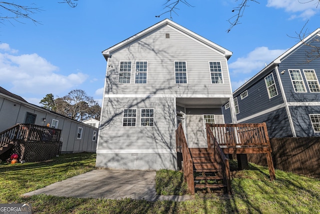 rear view of property with a lawn, fence, a wooden deck, crawl space, and stairs