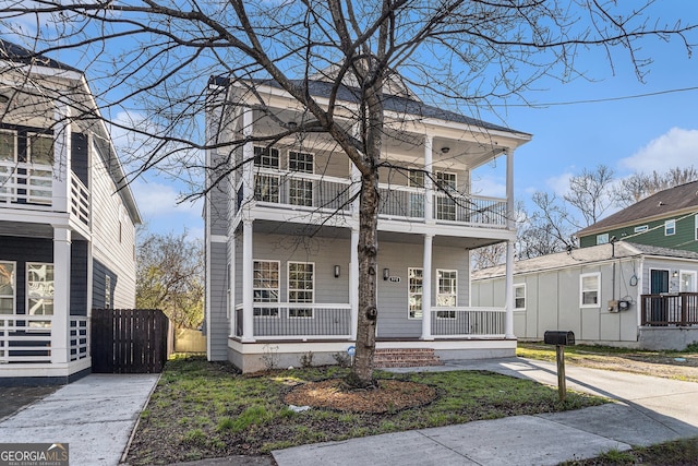view of front of house featuring a balcony, a porch, and a chimney