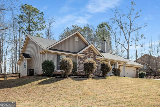 view of front of home featuring a front yard, an attached garage, central AC, a chimney, and stone siding