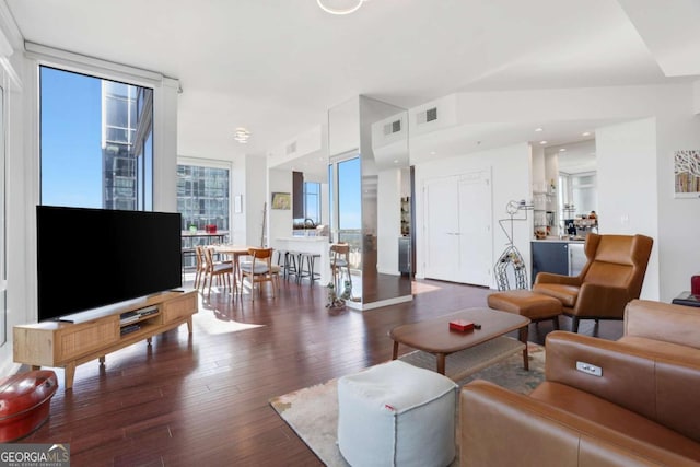 living area featuring visible vents, expansive windows, and hardwood / wood-style flooring