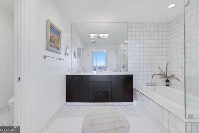 bathroom featuring tile patterned floors, a garden tub, a sink, double vanity, and tiled shower