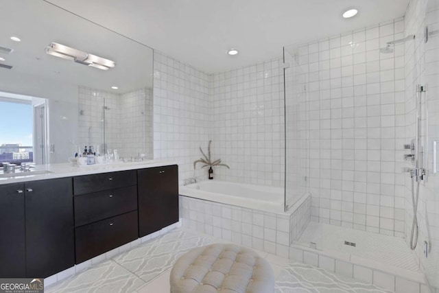 bathroom featuring a garden tub, a sink, tile walls, double vanity, and tiled shower