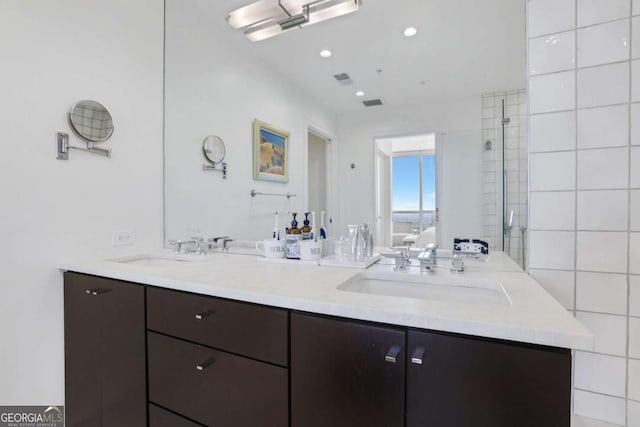 ensuite bathroom featuring a sink, visible vents, recessed lighting, and double vanity