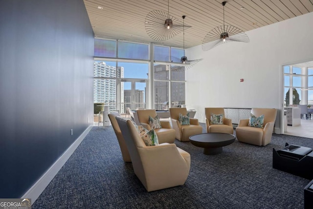 carpeted living room with a wall of windows, baseboards, a towering ceiling, a city view, and wooden ceiling