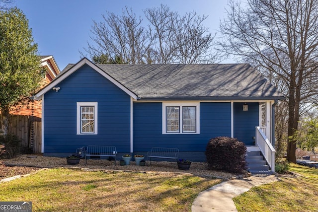 single story home with roof with shingles, a front lawn, and fence