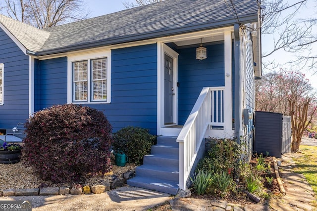 property entrance featuring a shingled roof