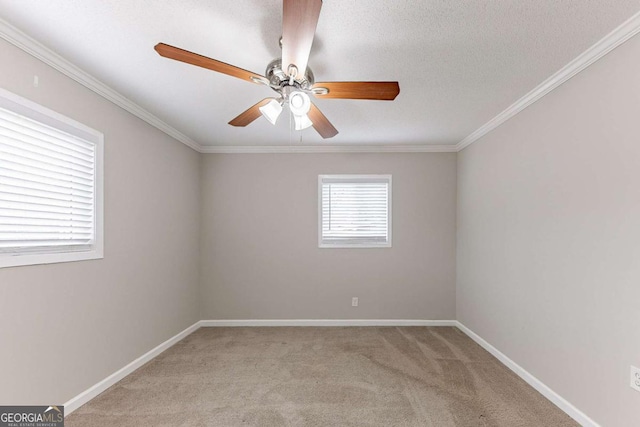 spare room featuring crown molding, light colored carpet, baseboards, and a textured ceiling