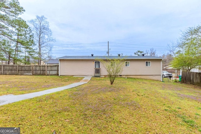 back of house featuring a yard and fence