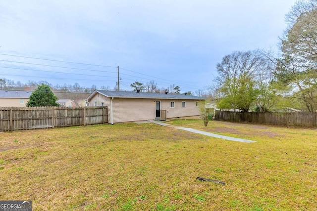 back of house featuring a yard and fence