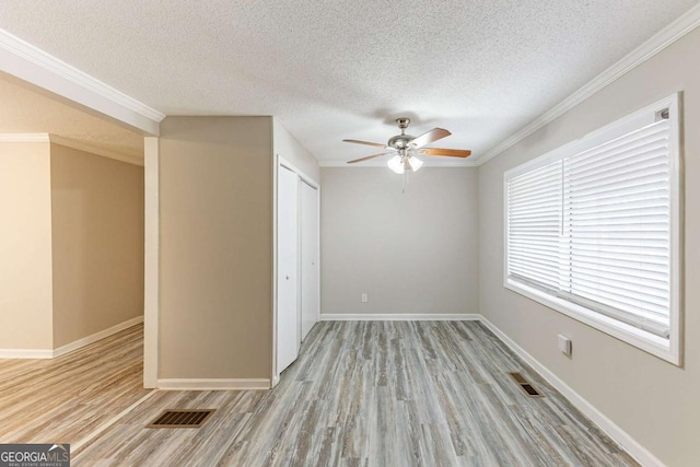 empty room featuring light wood-type flooring, visible vents, and baseboards