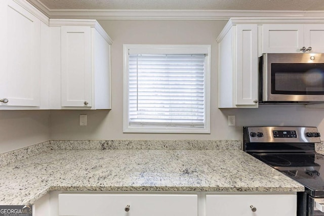 kitchen featuring white cabinetry, crown molding, light stone countertops, and stainless steel appliances