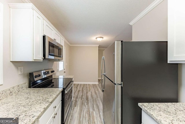 kitchen with light wood-style flooring, appliances with stainless steel finishes, white cabinetry, and crown molding