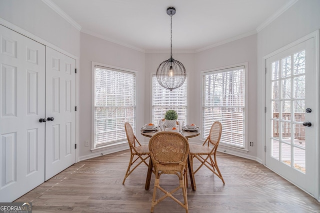 dining room with light wood-style flooring, baseboards, and ornamental molding