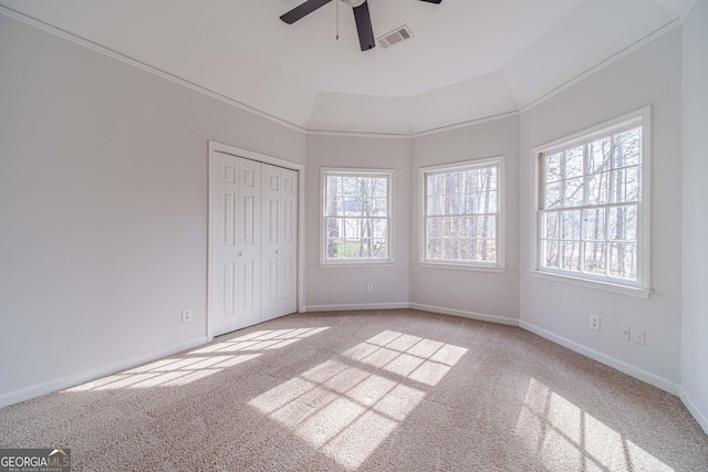 unfurnished bedroom with multiple windows, light colored carpet, visible vents, and baseboards