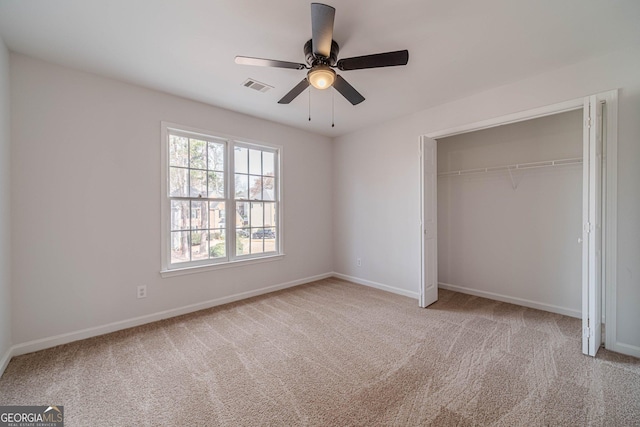 unfurnished bedroom featuring visible vents, a closet, carpet flooring, baseboards, and ceiling fan