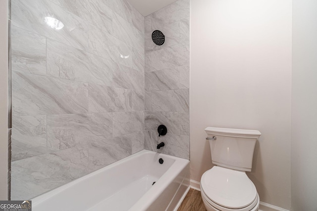 full bath with toilet, baseboards, and shower / bath combination