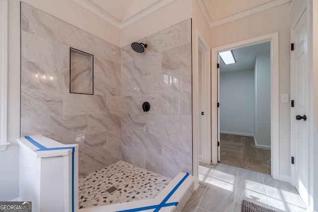 full bath with baseboards, a tile shower, and ornamental molding