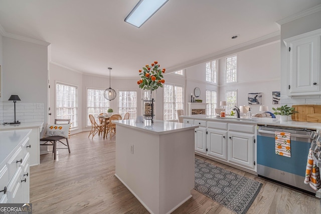 kitchen with light wood-style floors, stainless steel dishwasher, and light countertops