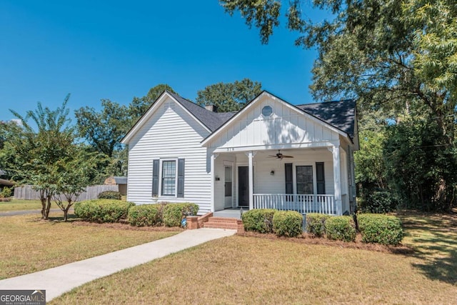 bungalow featuring ceiling fan, a porch, board and batten siding, and a front lawn