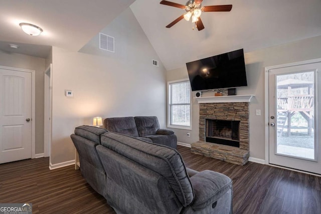 living room with a fireplace, visible vents, dark wood-style flooring, and high vaulted ceiling