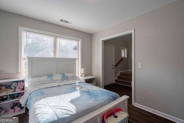 bedroom with visible vents, baseboards, and dark wood-style flooring