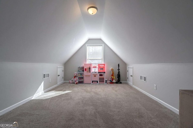 playroom with vaulted ceiling, visible vents, baseboards, and carpet floors