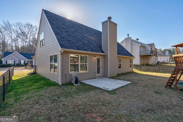 rear view of property featuring a patio, a yard, a fenced backyard, and a chimney