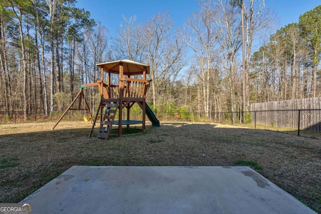 view of jungle gym featuring a yard, a patio, and fence