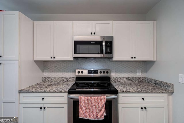 kitchen with light stone countertops, backsplash, appliances with stainless steel finishes, and white cabinetry