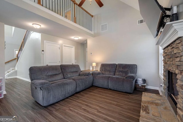 living room featuring dark wood finished floors, a fireplace, and visible vents